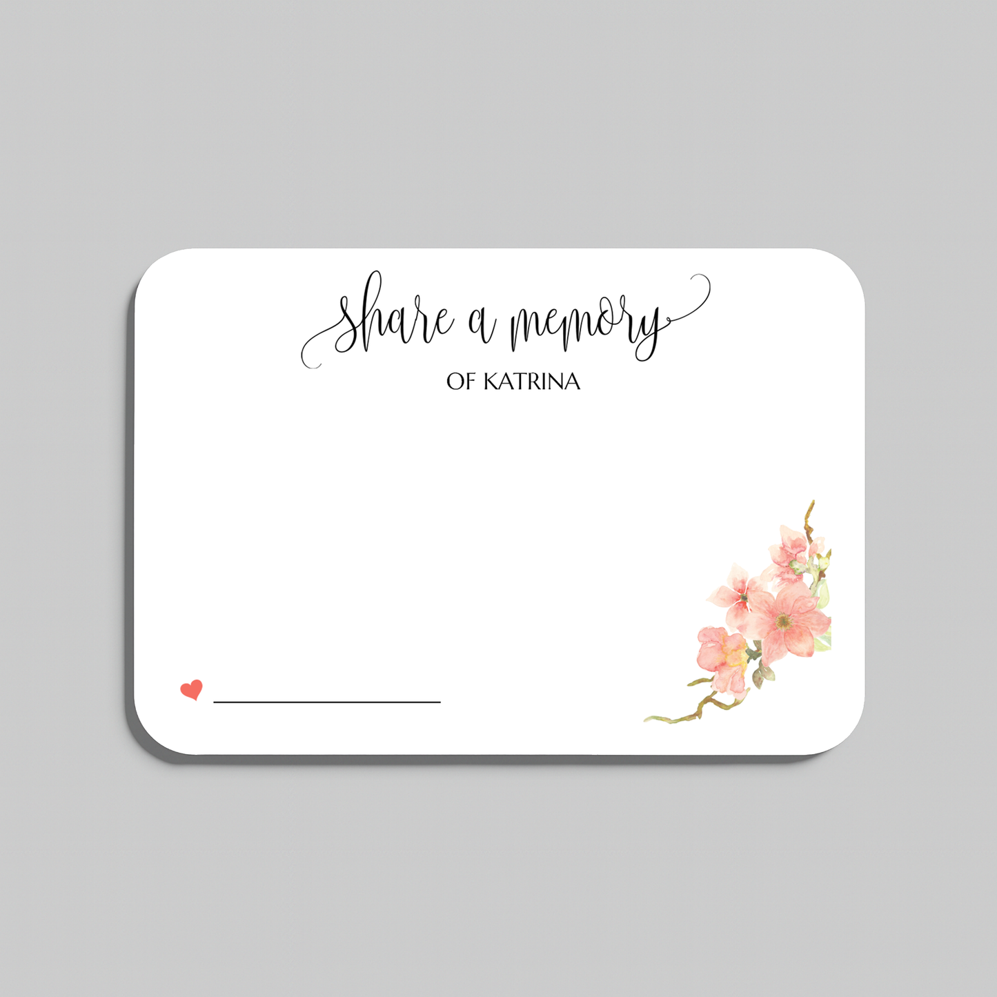 A rectangular white memorial card with rounded corners, printed with the words share a memory in black script and serif text, plus small pink floral artwork in the lower right and a small red heart with a line for writing in the lower left. The card is shown on a light gray background.
