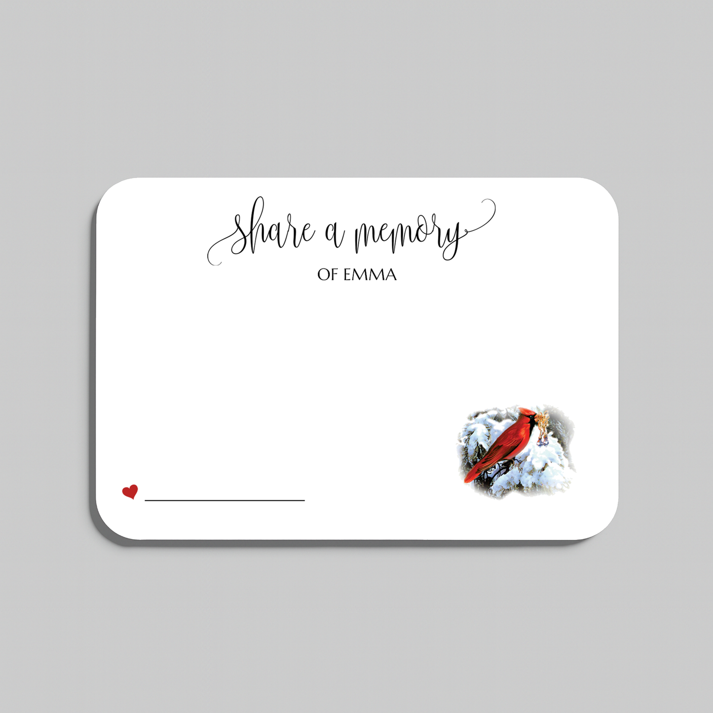 A memorial card with rounded corners on a light gray background. The card is white with black script text reading 'share a memory' a small red heart and line in the lower left, and a small red cardinal perched on white snow in the lower right.