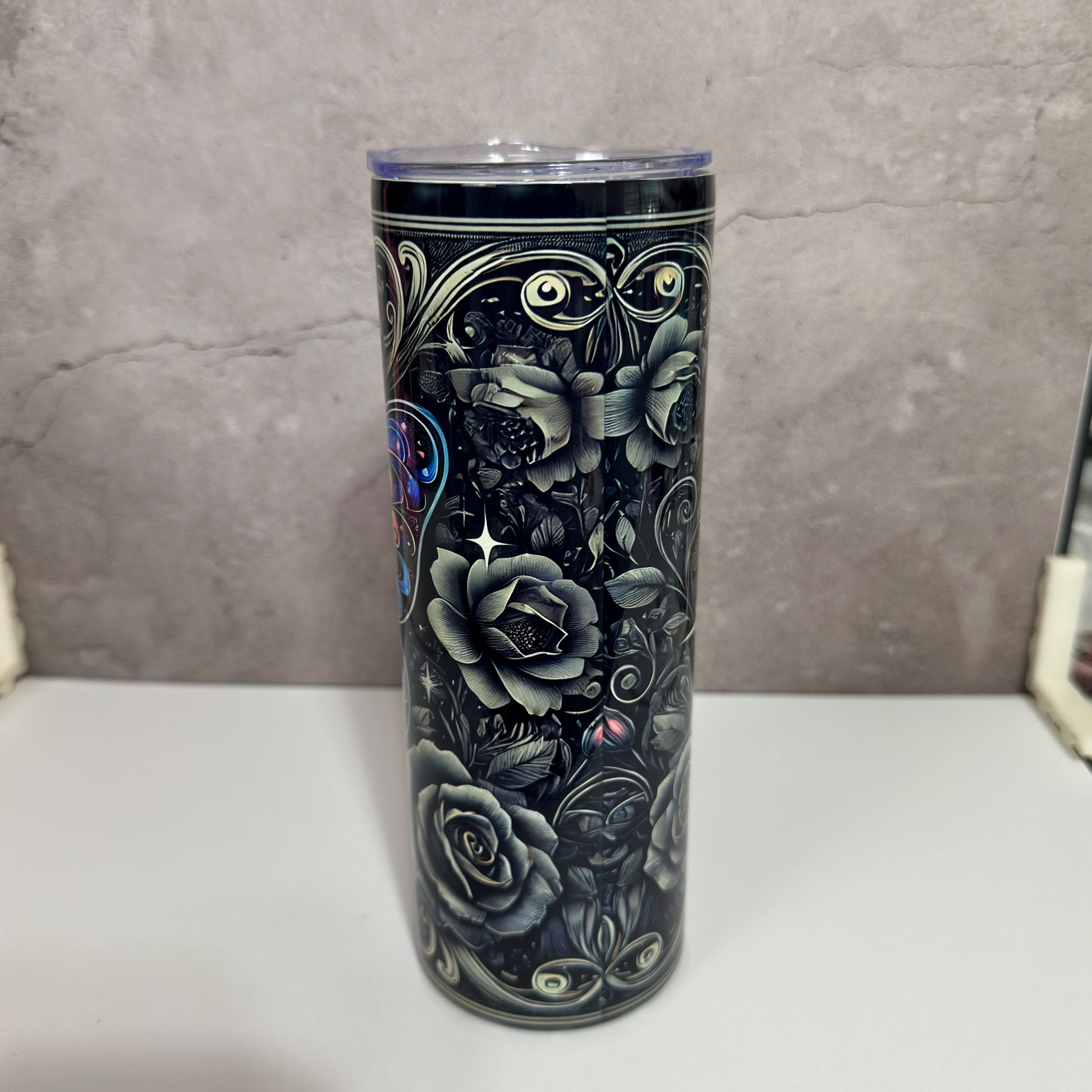 Tumbler with black floral design on a gray background