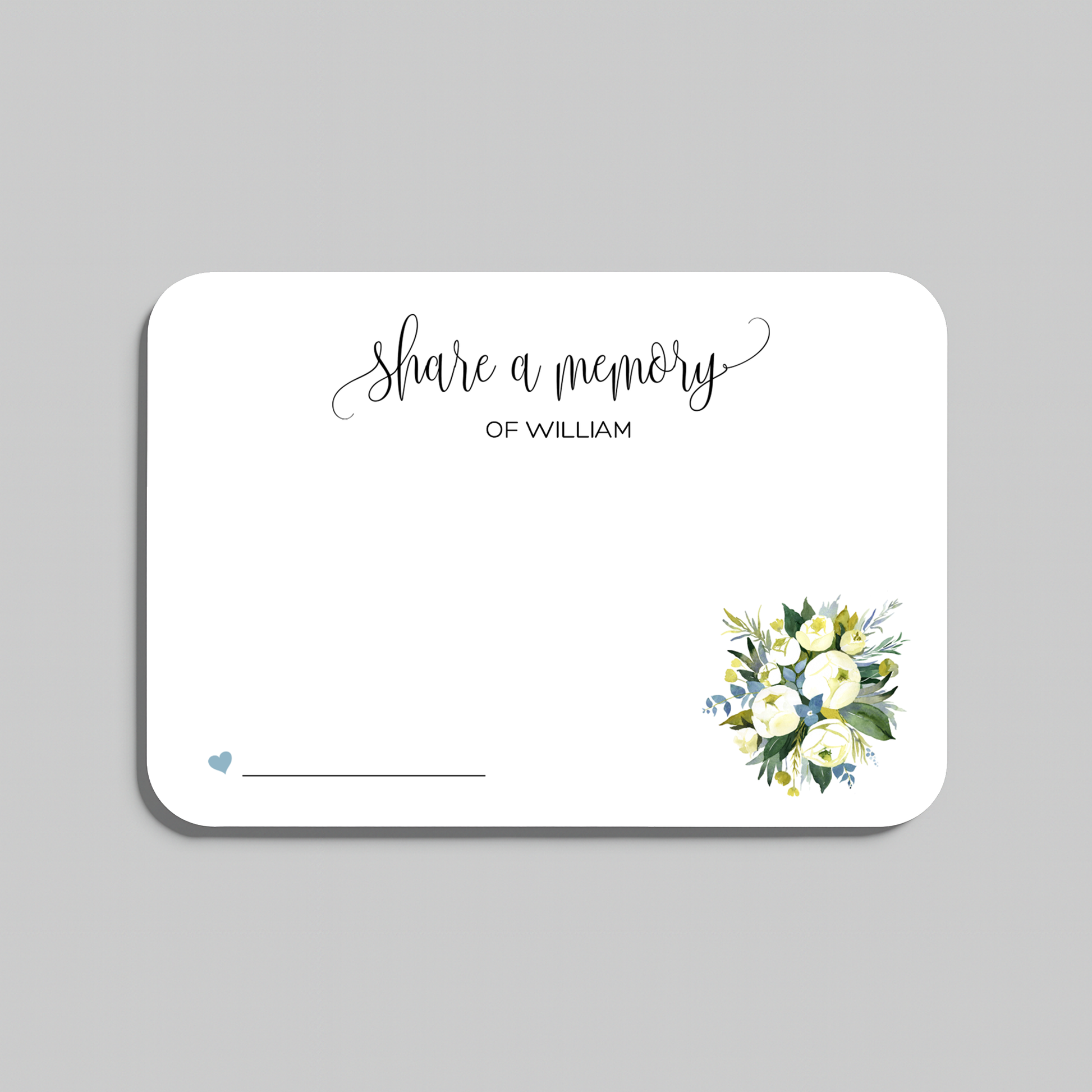 A rectangular white memorial card with rounded corners, featuring the script text 'Share a memory at the top, a small blue heart and line at the bottom left, and a watercolor floral bouquet in white, yellow, and green at the bottom right. The card is shown on a light gray background.