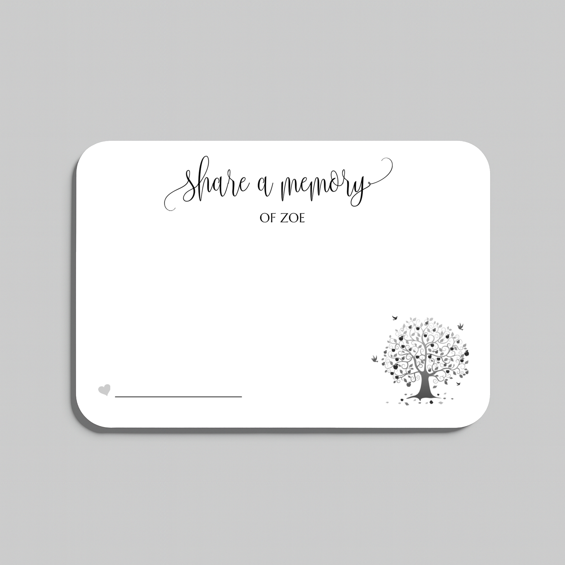 A white rectangular memorial card with rounded corners, featuring the black script text share a memory at the top, a small heart icon with a line at the bottom left, and a black tree illustration with scattered leaves in the lower right. The card is centered on a light gray background.