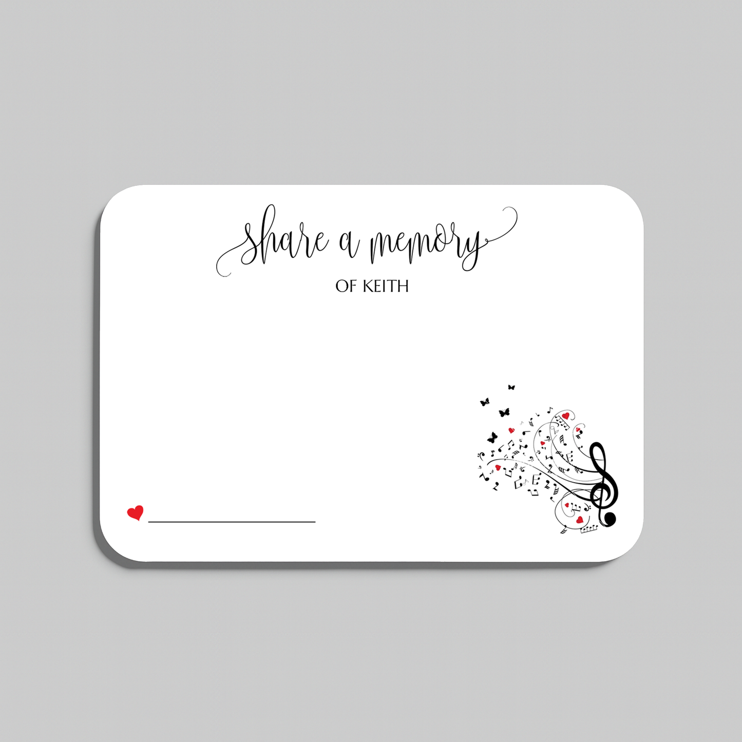 A white memorial card with rounded corners, featuring the script text 'share a memory' at the top, a small red heart and line in the lower left, and black musical notes and treble clefs with small red hearts in the lower right. The card is shown on a light gray background.
