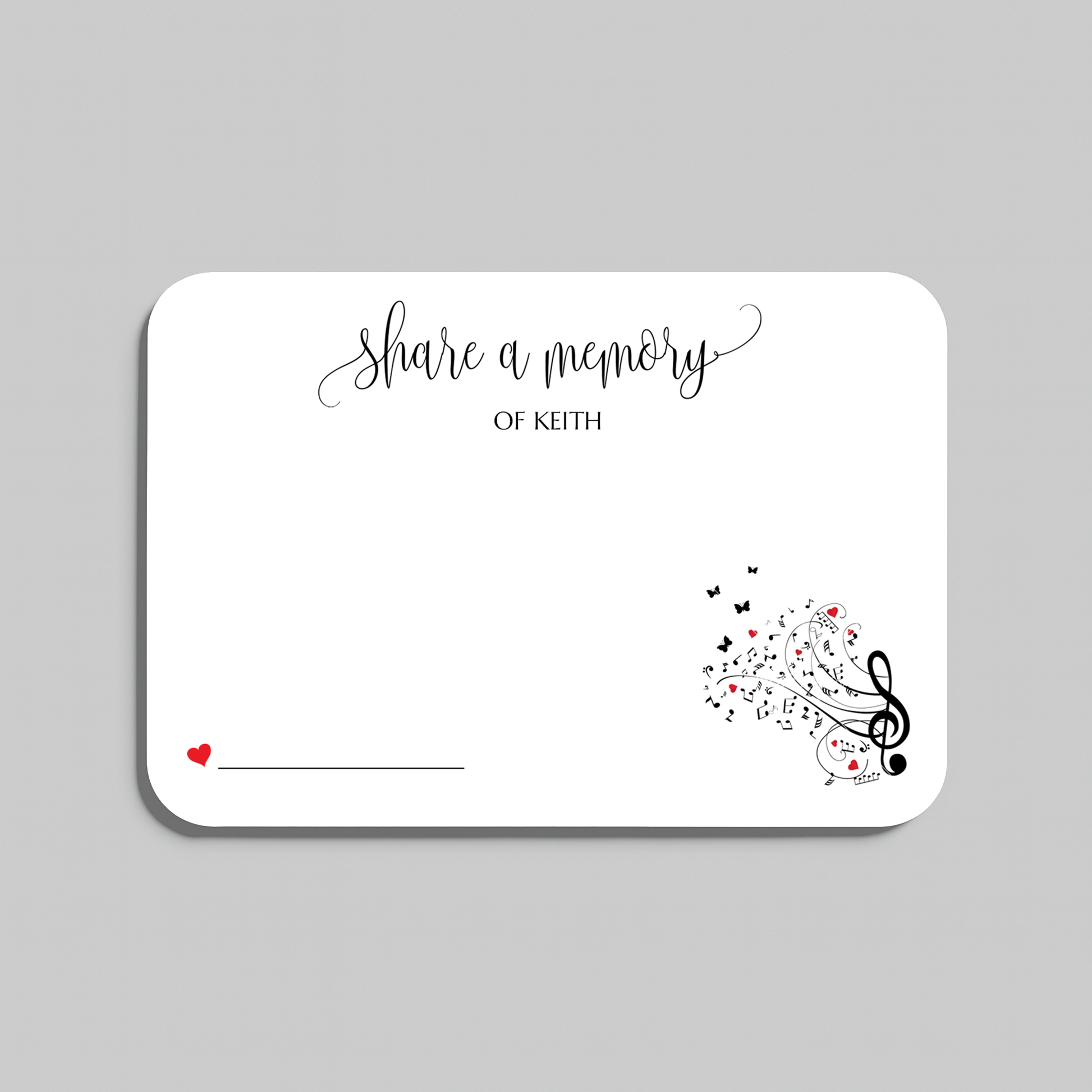 A white memorial card with rounded corners, featuring the script text 'share a memory' at the top, a small red heart and line in the lower left, and black musical notes and treble clefs with small red hearts in the lower right. The card is shown on a light gray background.