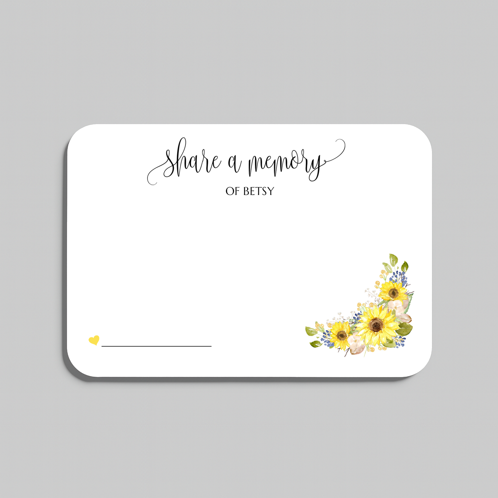 A white rectangular memorial card with rounded corners, featuring the script text 'share a memory' at the top, a blank line at the bottom left for writing a name, and a watercolor sunflower cluster in yellow, green, and blue at the bottom right. The card is shown on a neutral gray background.