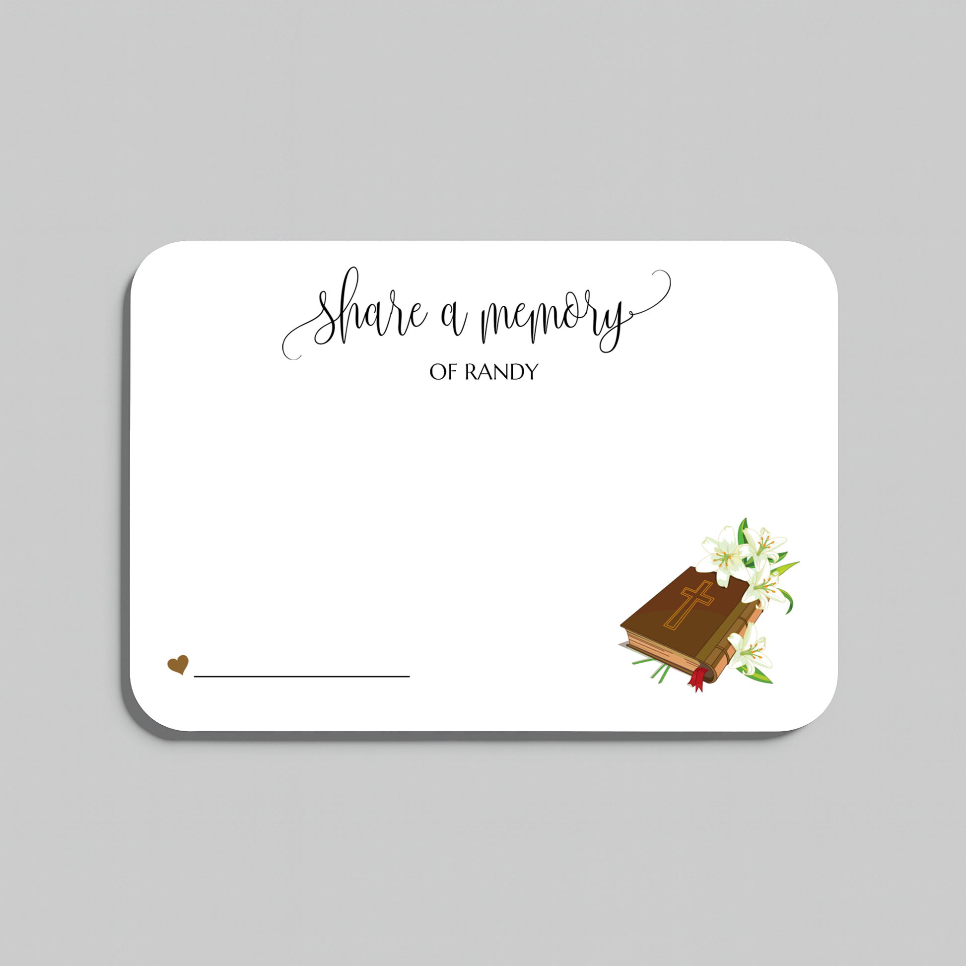 A rectangular white memorial card with rounded corners, featuring the printed text 'share a memory' in black script and serif fonts, plus a small illustration of a bible with lily's and a heart near the bottom left. The card is shown on a plain light gray background.
