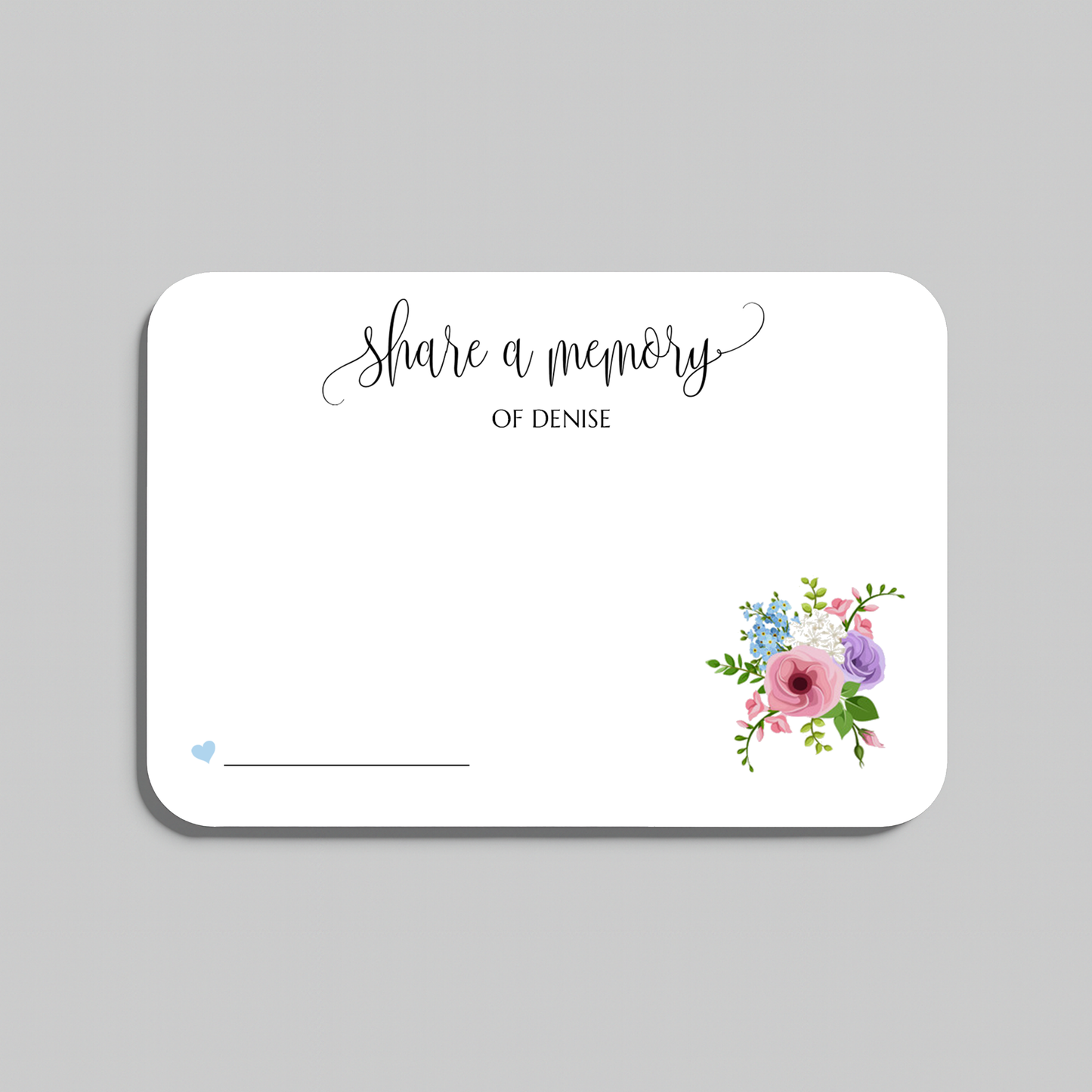 A white rectangular memorial card with rounded corners, featuring the script text 'share a memory' at the top, a blank line at the bottom left, and a small watercolor floral arrangement in the lower right corner. The card is shown on a neutral gray background.