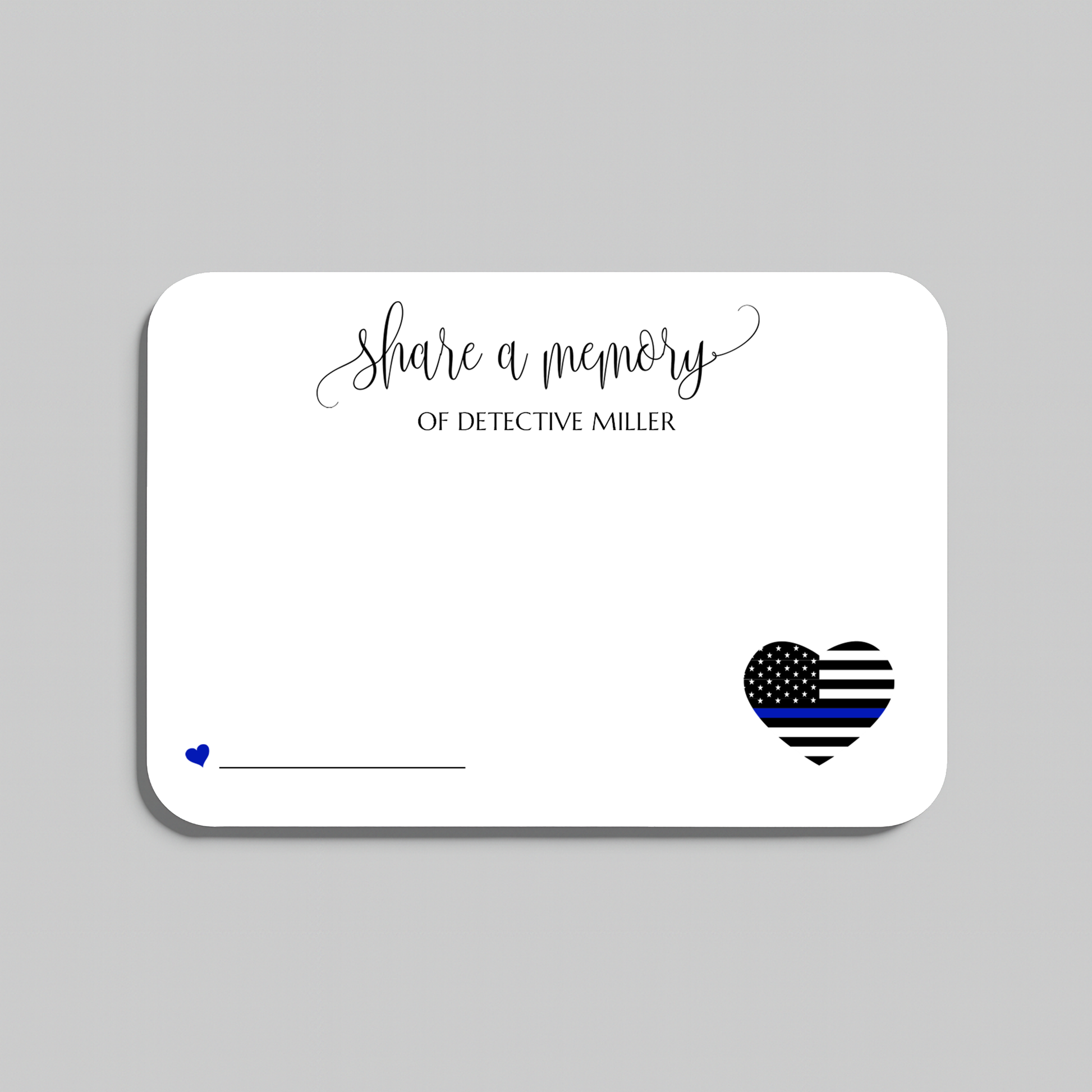 A white rectangular memorial card with rounded corners on a light gray background. The card features the script text 'share a memory' at the top, a small blue heart and line on the lower left, and a black-and-white striped heart with a blue stripe on the lower right for law enforcement memorials