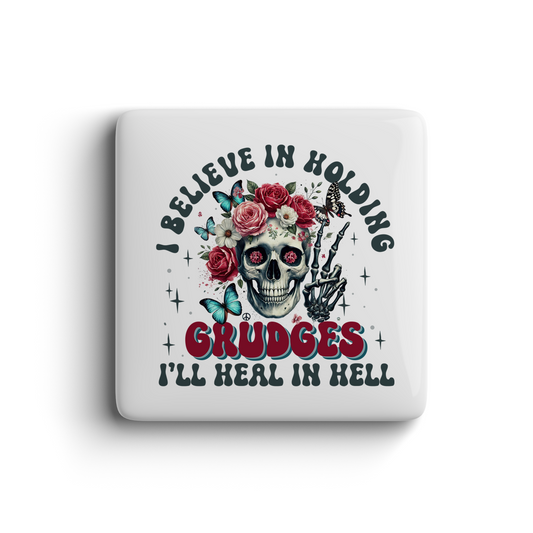 Skull magnet with floral crown, butterflies, and gothic text “I Believe in Holding Grudges I’ll Heal in Hell”