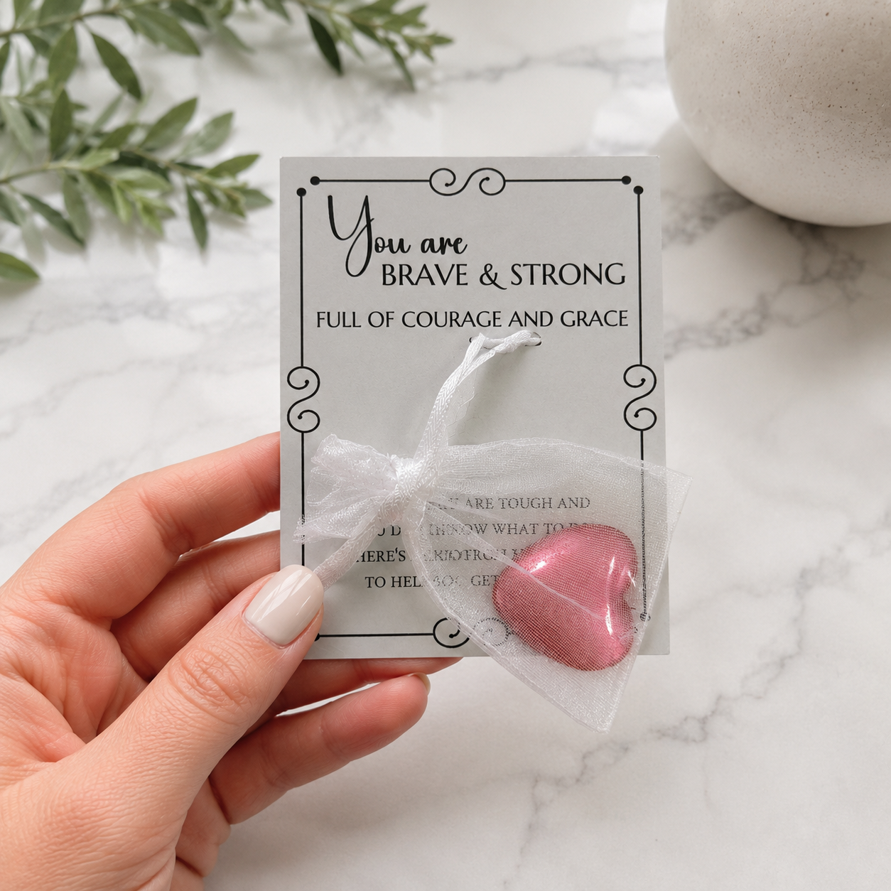Inspirational pocket hug keepsake with a heart-shaped token on a "You Are Brave & Strong" encouragement card, a thoughtful comfort gift for friends, family, coworkers, or anyone needing support Packaged in a small organza bag and placed inside a cellophane sleeve for easy gift giving.
